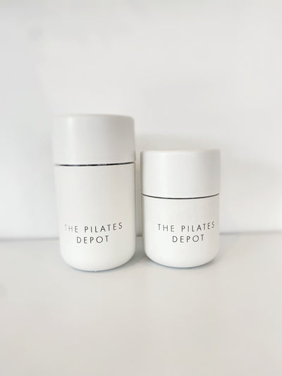two white cups with the pilates depot engraved on them. one larger than the other