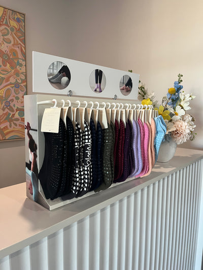 right side view of a TPD Store Grippy sock wholesale display rack with many pairs of grippy socks