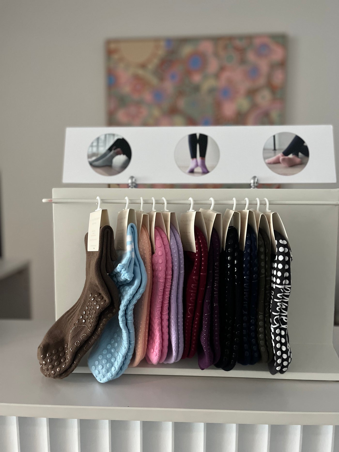 TPD Store grippy sock display rack on a shelf with socks in many colours