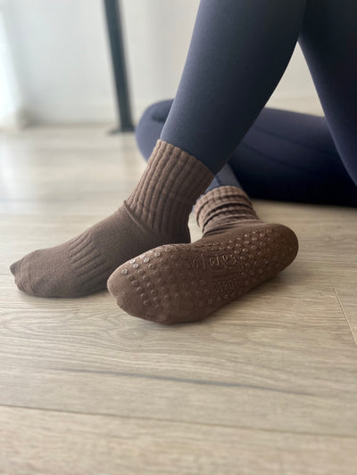 A pair of feet in Mocha Brown TPD Store Grippy Socks ready for pilates practice