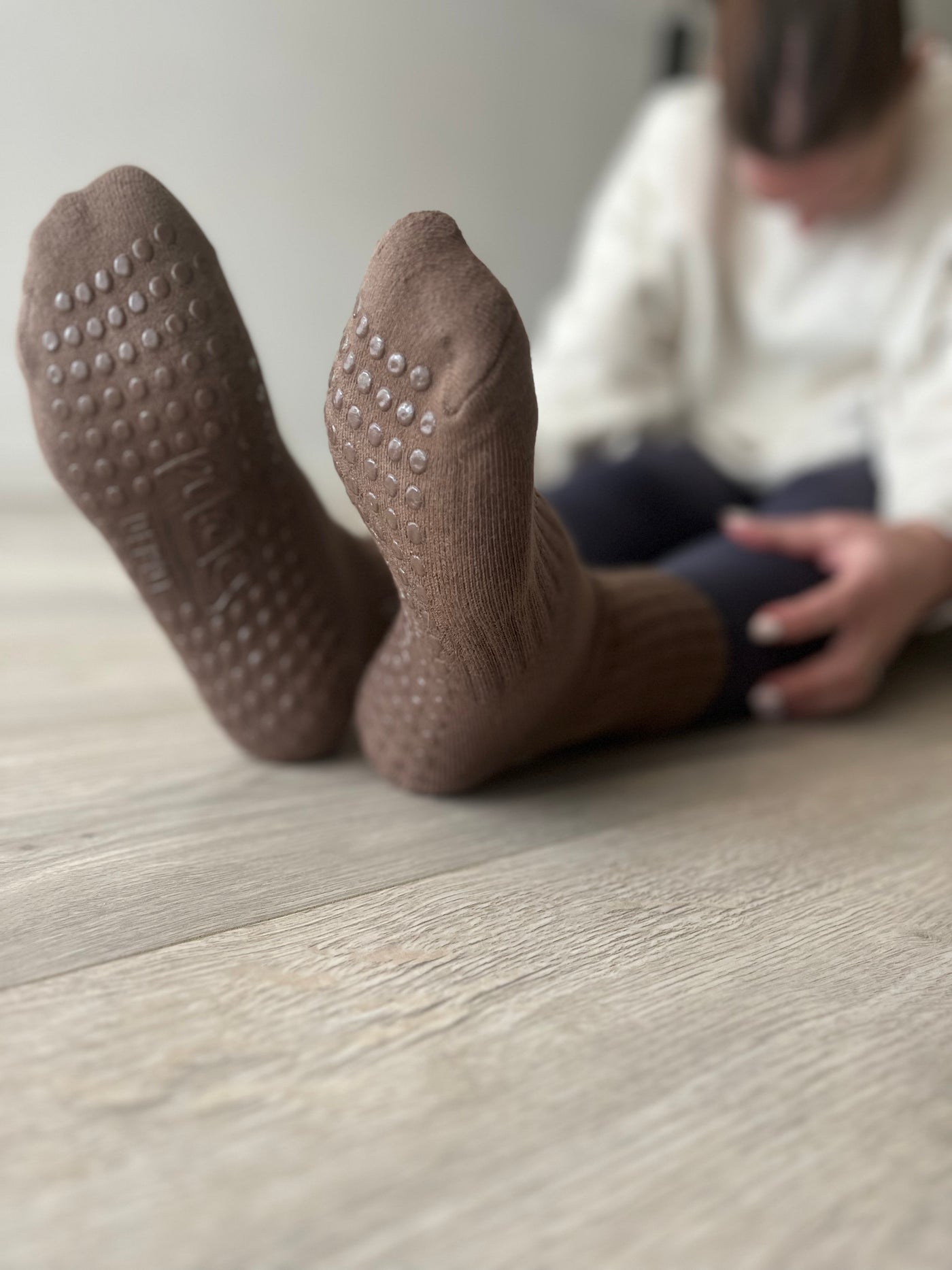 A pair of flexed feet in Mocha Brown TPD Store Grippy socks
