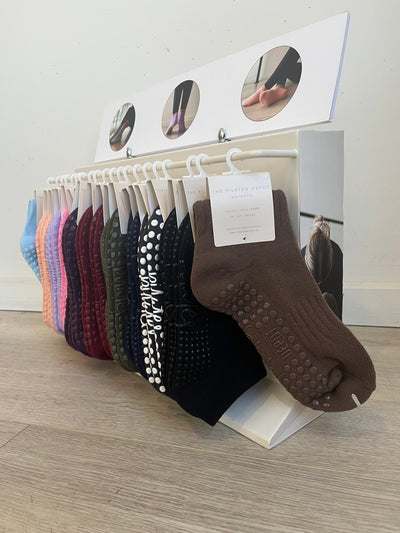 TPD Store Grippy sock rack with mocha brown grippy socks on display