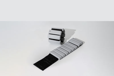 pair of tpd store grey ankle weights on white background. One unrolled and one in a ring