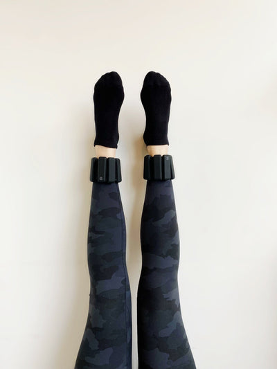 legs resting up the wall with pair of tpd store matt black ankle weights