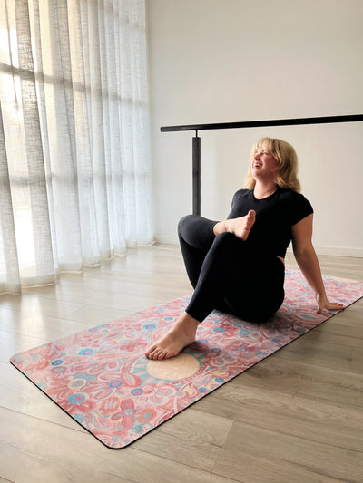 woman sitting on you are my sunshine tpd store eco friendly yoga mat in resting pose with one foot resting on the other knee