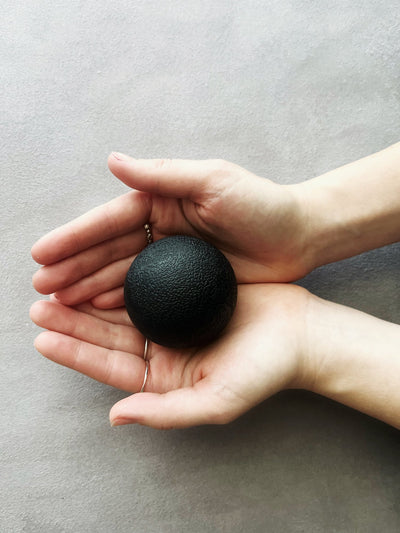 cupped hands holding a black tpd store tigger ball