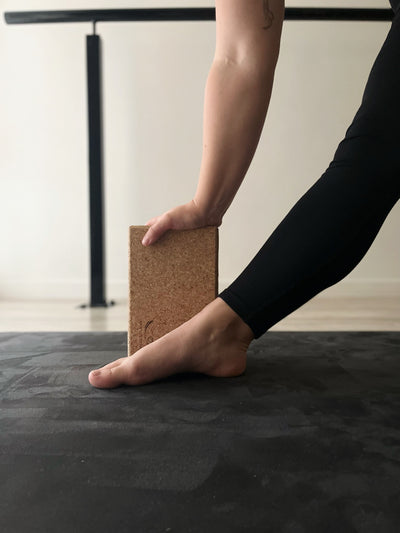 woman using a tpd store cork block to support her hand as part of yoga practice