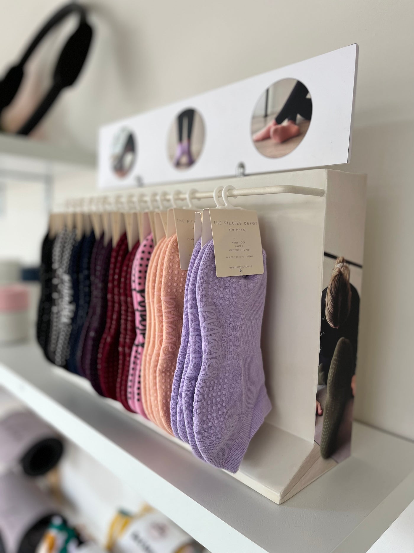TPD Store Grippy socks display rack on a shelf with a side angle view
