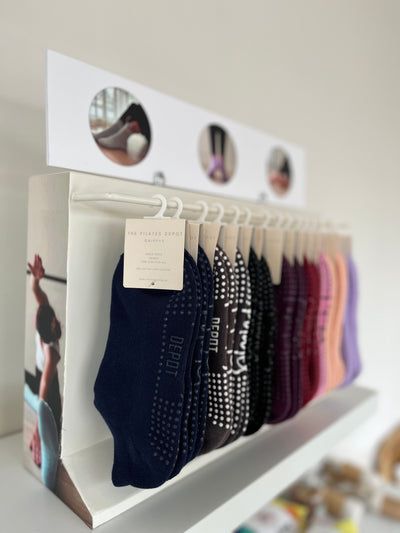 shelf holding a tpd store wholesale grippy sock rack to hold multiple colours of low and high rise grippy socks on display