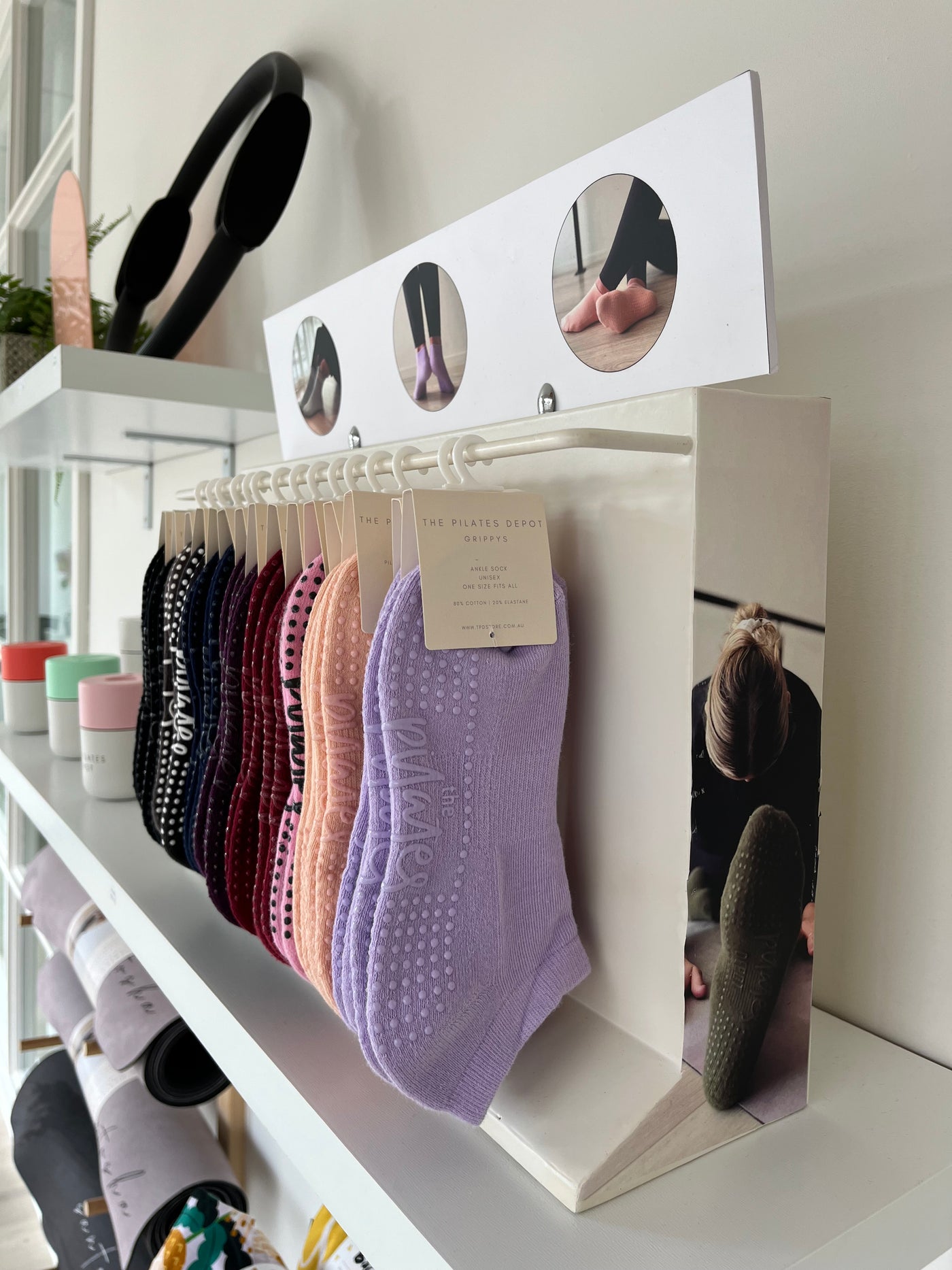 a shelf holding a rack of TPD store grippy socks in a variety of colours