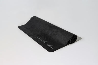 rolled up black tpd store eco friendly yoga mat on white background