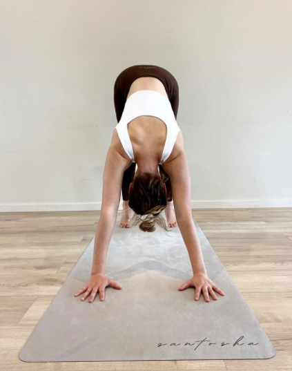 woman in downward dog pose on stone tpd store eco friendly yoga mat