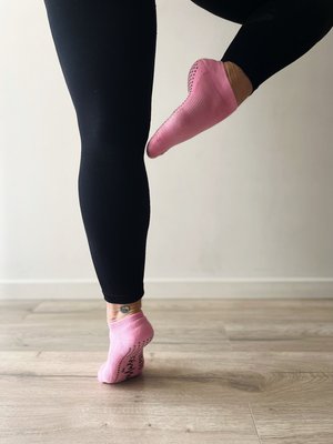 woman in one leg stand wearing blush pink low rise tpd store grippy socks